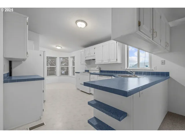 a kitchen with stainless steel appliances granite countertop a sink a stove and a refrigerator