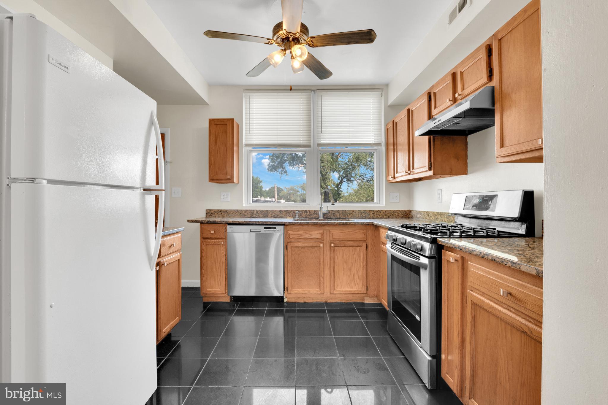 5731 9th Street Northwest Washington, DC 20011 - Photo 15 of 36 a kitchen with white cabinets a sink a stove and a refrigerator