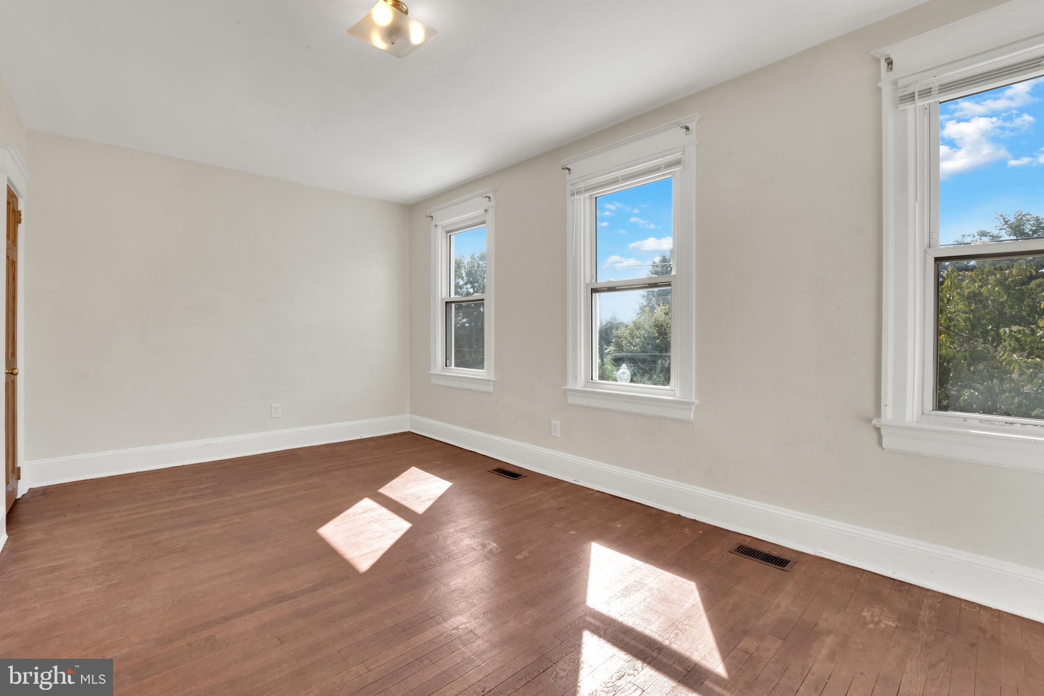 5731 9th Street Northwest Washington, DC 20011 - Photo 18 of 36 a view of an empty room with wooden floor and a window