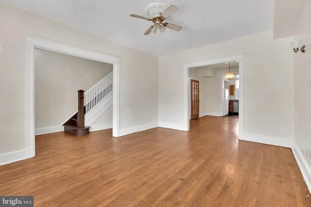 a view of a room with wooden floor and a ceiling fan