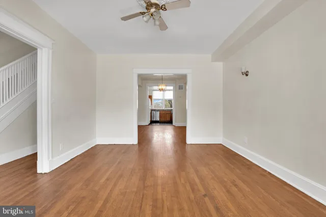 a view of a room with wooden floor and ceiling fan