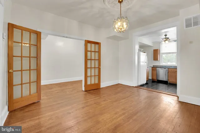 a view of an empty room with window and wooden floor