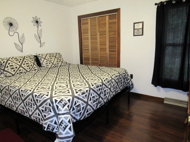 309 Cedar Drive Clinton, IL 61727 - Photo 16 of 20 a bedroom with a bed and wooden floor