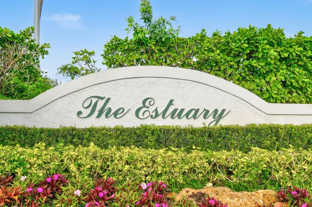 a view of a lake with a yard and large trees