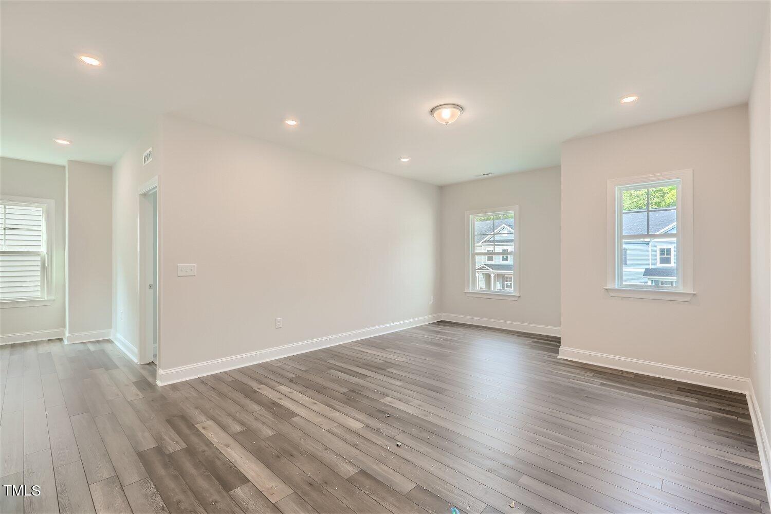 544 Tanner Lake Lane, Unit 294 Raleigh, NC 27610 - Photo 15 of 16 an empty room with wooden floor and windows