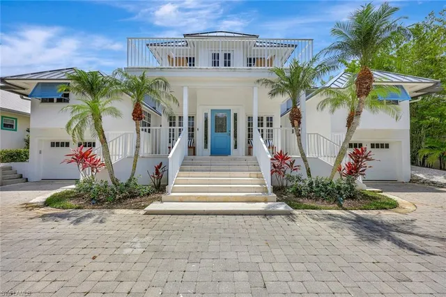 a front view of a house with a yard and potted plants