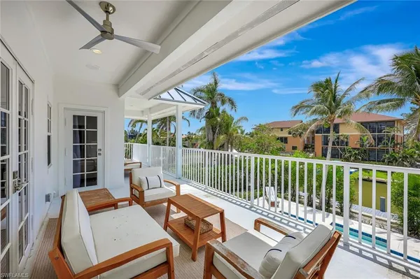 a living room with furniture a clock and a large window