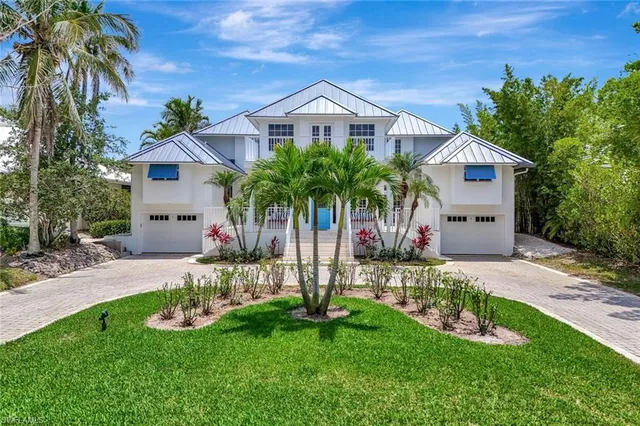 a front view of a house with a yard and potted plants