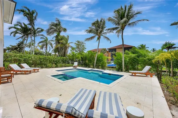 a view of a swimming pool with lounge chairs in patio