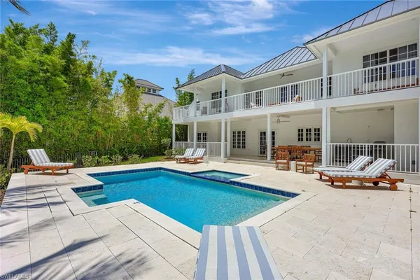 a view of a house with swimming pool and sitting area