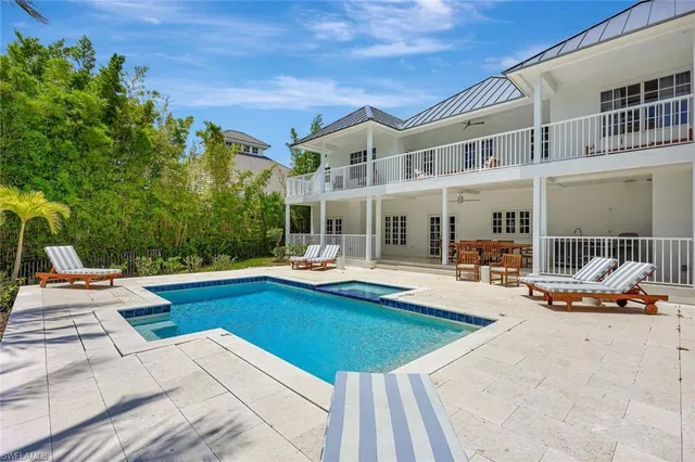 a view of a house with swimming pool and sitting area