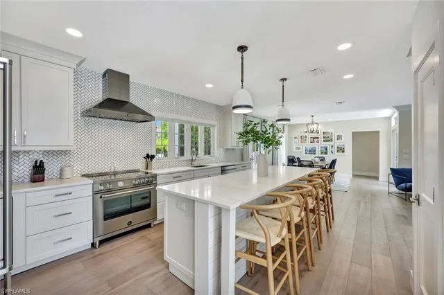 a kitchen with stainless steel appliances kitchen island granite countertop a stove a sink and a refrigerator