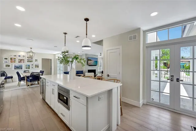 a large white kitchen with a large window and stainless steel appliances
