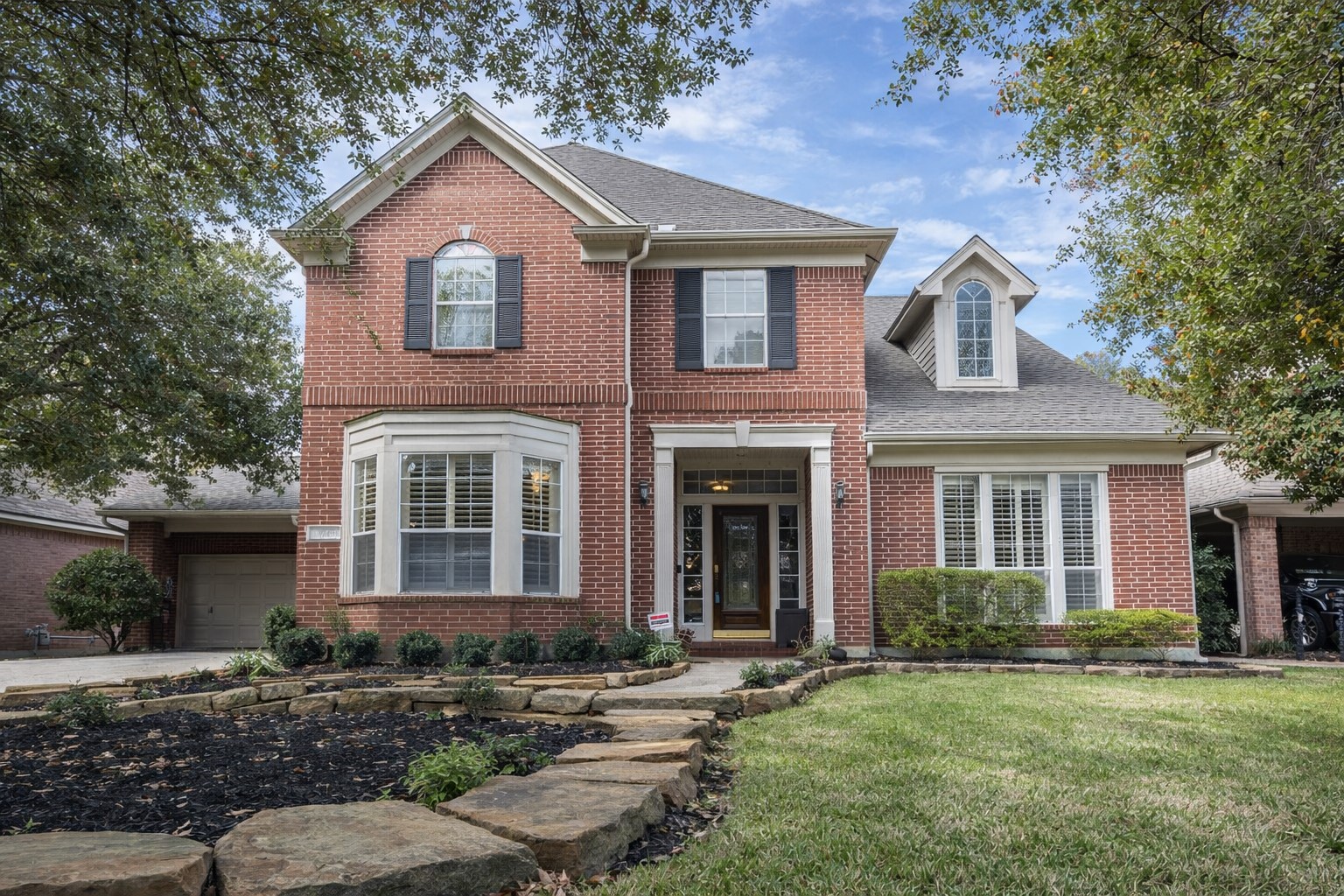 Discover your dream home at 5718 Oakmoss Trail—a charming brick facade nestled amidst serene greenery.