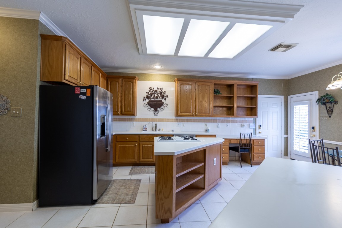 5718 Oakmoss Trail Spring, TX 77379 - Photo 16 of 50 Bright island kitchen with abundant storage and stainless-steel appliances, including a 2023 refrigerator and dishwasher.