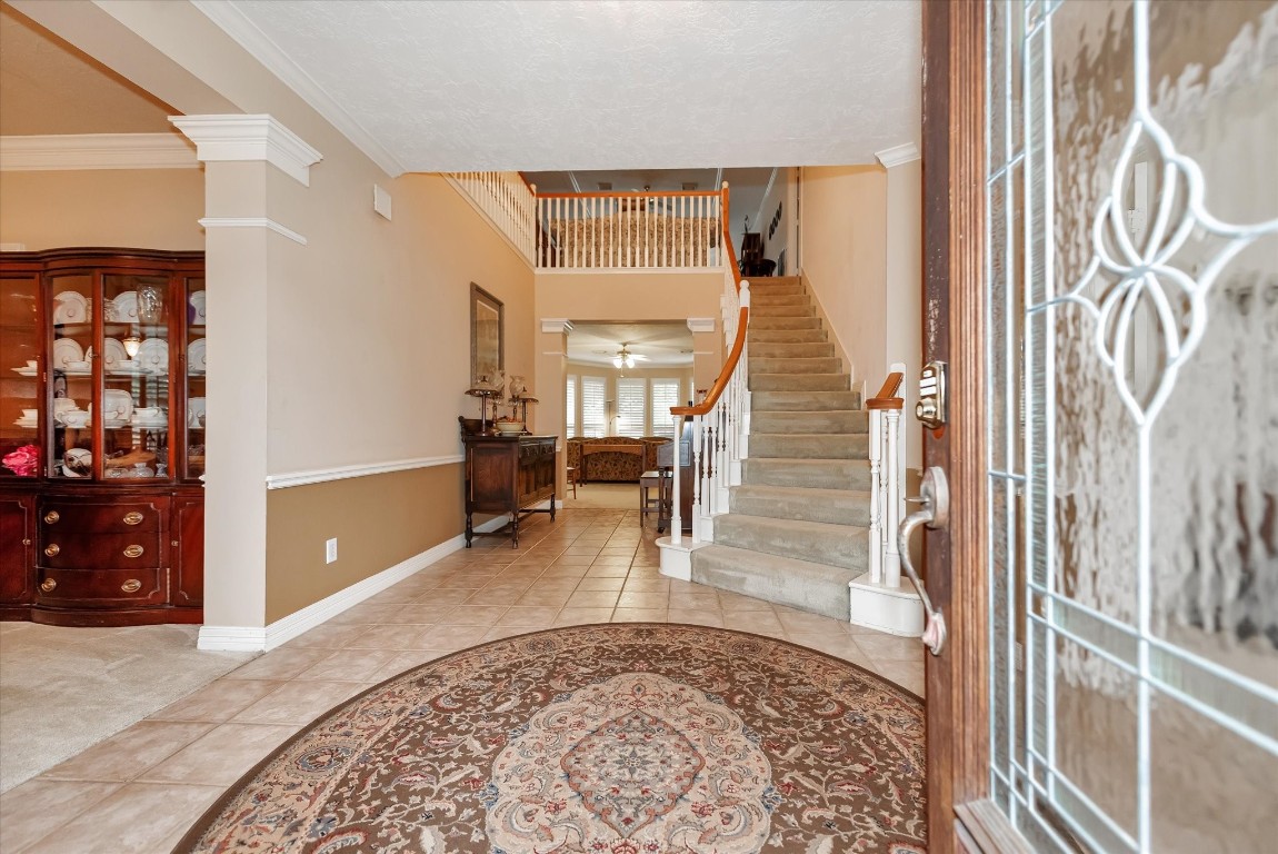 5718 Oakmoss Trail Spring, TX 77379 - Photo 7 of 50 Step into elegance with a grand two-story foyer featuring decorative tile and a sweeping staircase.