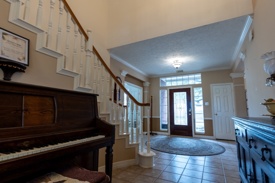 5718 Oakmoss Trail Spring, TX 77379 - Photo 9 of 50 Welcome to a stunning entryway with elegant tile flooring, a grand staircase, and a spacious hallway.
