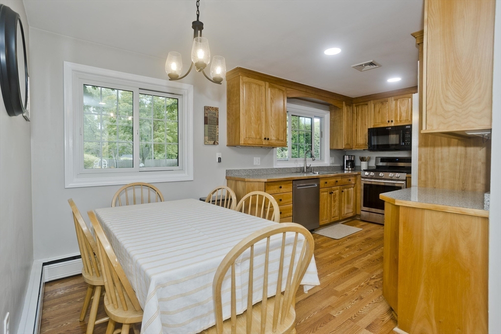 213 Spring Grove Avenue Northampton, MA 01062 - Photo 8 of 41 a kitchen with granite countertop a stove a sink a dining table and chairs