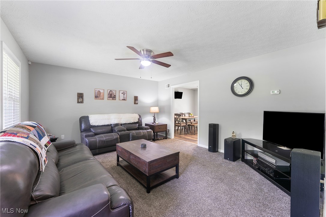 1761 Rustic Run Road Warren, OH 44481 - Photo 24 of 45 Carpeted living room with a textured ceiling and a ceiling fan