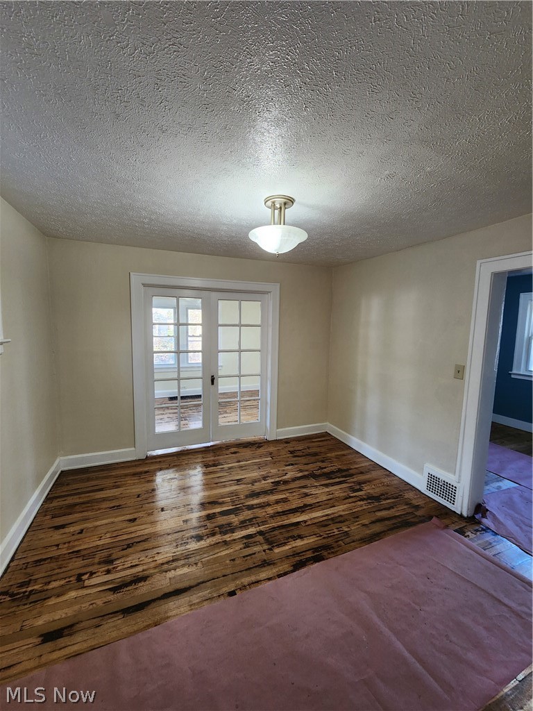 13500 Rugby Road Cleveland, OH 44110 - Photo 6 of 18 Empty room with french doors, a textured ceiling, and hardwood / wood-style floors