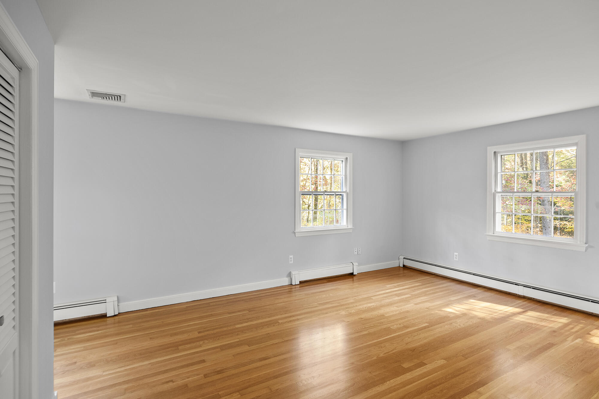 10 Pilgrim Road Darien, CT 06820 - Photo 25 of 31 an empty room with wooden floor and windows