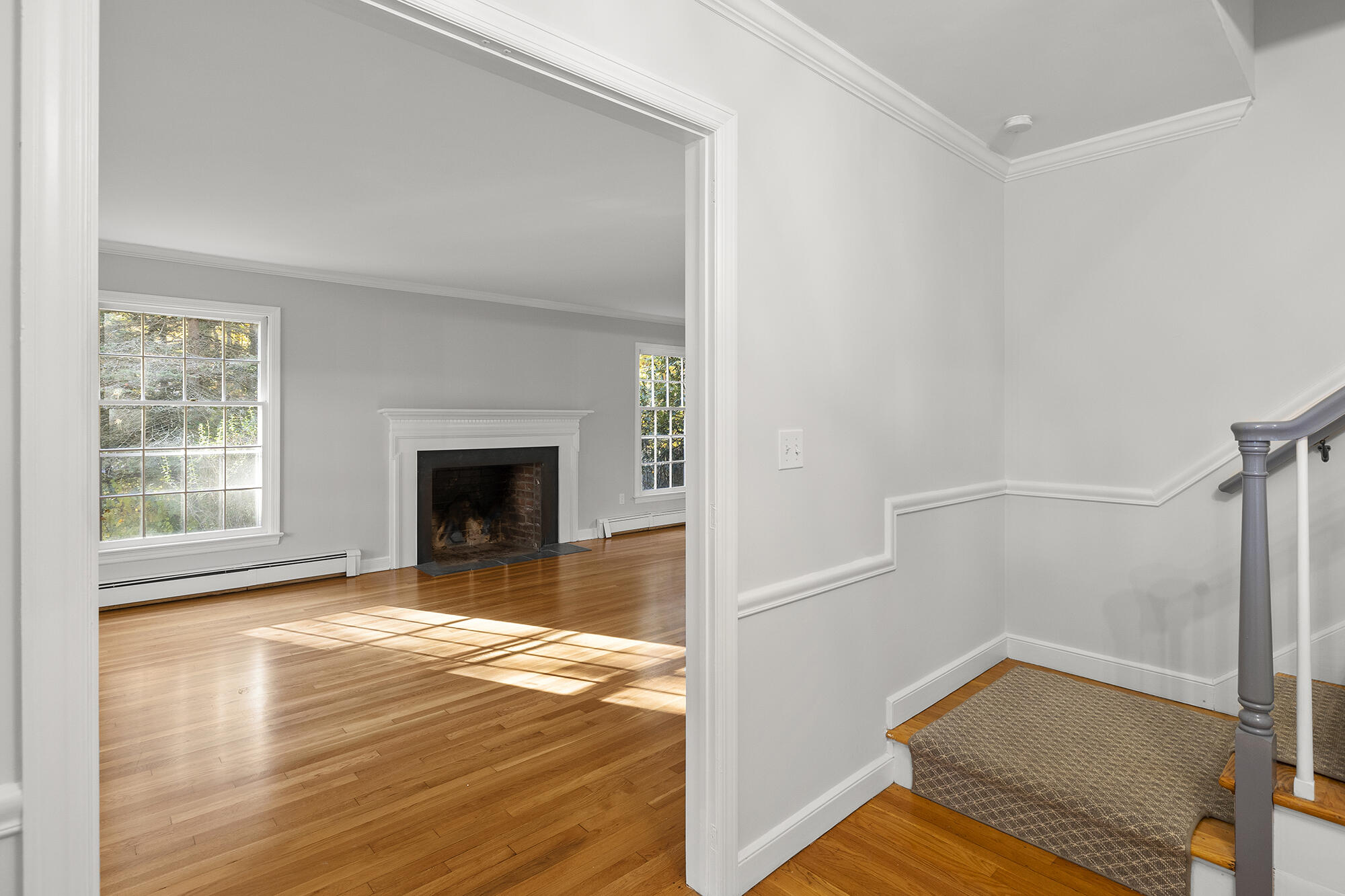 10 Pilgrim Road Darien, CT 06820 - Photo 5 of 31 a view of empty room with wooden floor and fireplace