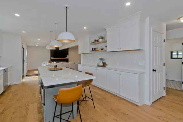 a kitchen with a table chairs refrigerator and microwave