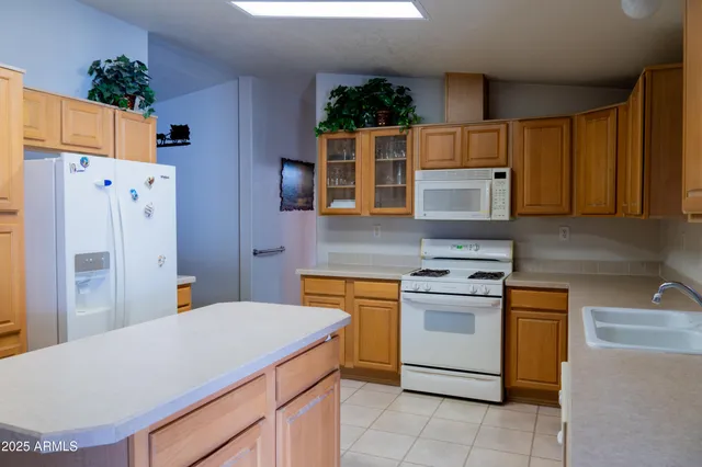 a kitchen with stainless steel appliances granite countertop a white cabinets a stove a sink and a refrigerator
