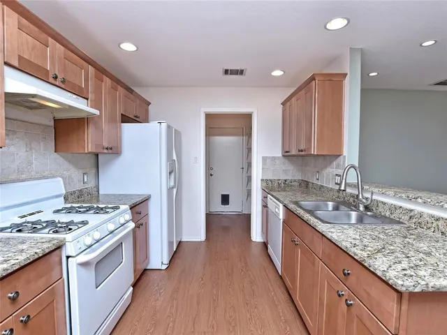 a kitchen with stainless steel appliances granite countertop a sink stove and refrigerator