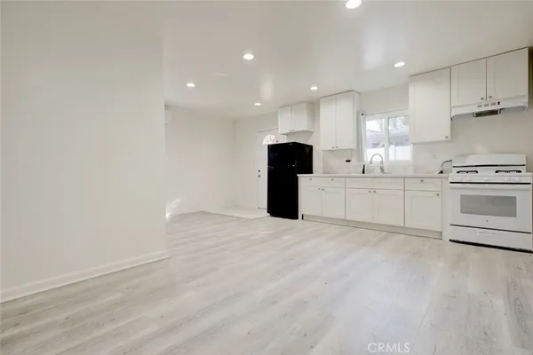 a large kitchen with white cabinets and stainless steel appliances