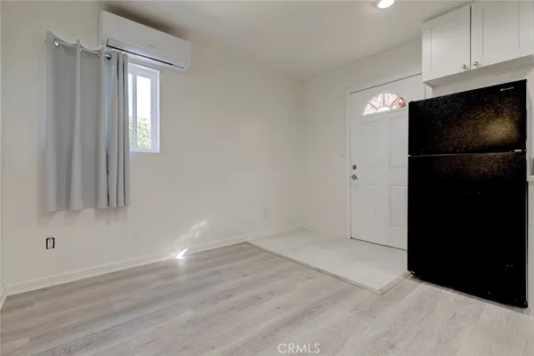 a view of empty room with wooden floor and cabinets
