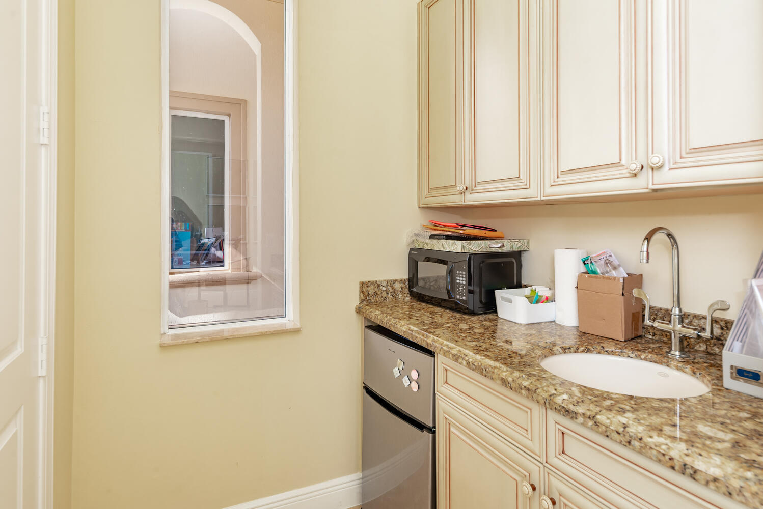 8849 Valhalla Drive Delray Beach, FL 33446 - Photo 29 of 32 a kitchen with granite countertop white cabinets and sink