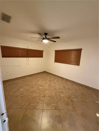 an empty room with a ceiling fan and a window