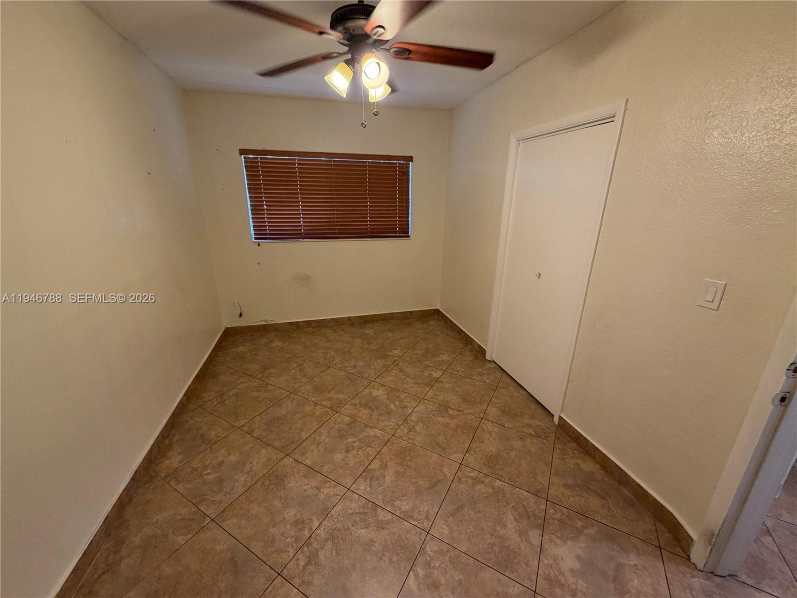 6090 West 5th Lane Hialeah, FL 33012 - Photo 12 of 28 an empty room with a ceiling fan and a window