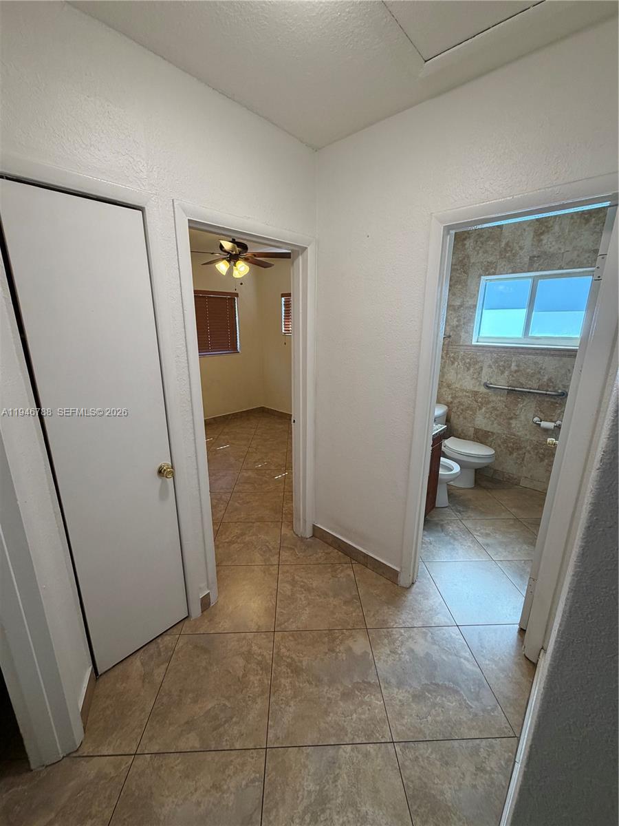 6090 West 5th Lane Hialeah, FL 33012 - Photo 15 of 28 a bathroom with a sink and glass door