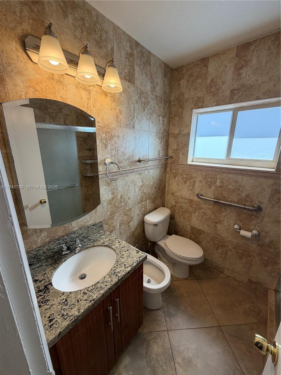6090 West 5th Lane Hialeah, FL 33012 - Photo 17 of 28 a bathroom with a granite countertop sink and a mirror