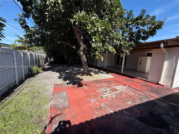 a view of a yard with plants and trees