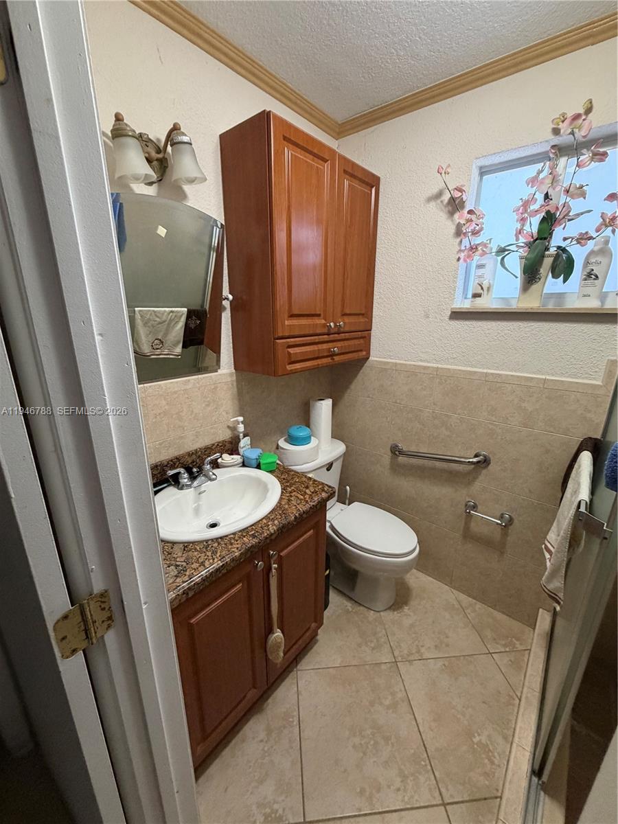 6090 West 5th Lane Hialeah, FL 33012 - Photo 26 of 28 a bathroom with a toilet a sink and mirror