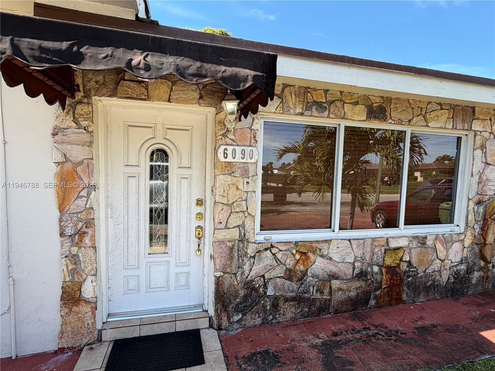 6090 West 5th Lane Hialeah, FL 33012 - Photo 3 of 28 a front view of a house with a yard