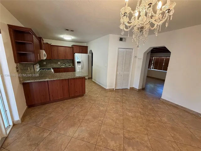 a view of a kitchen with a sink and a refrigerator