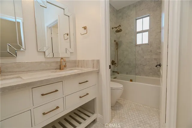 a bathroom with a granite countertop toilet a sink and a bathtub