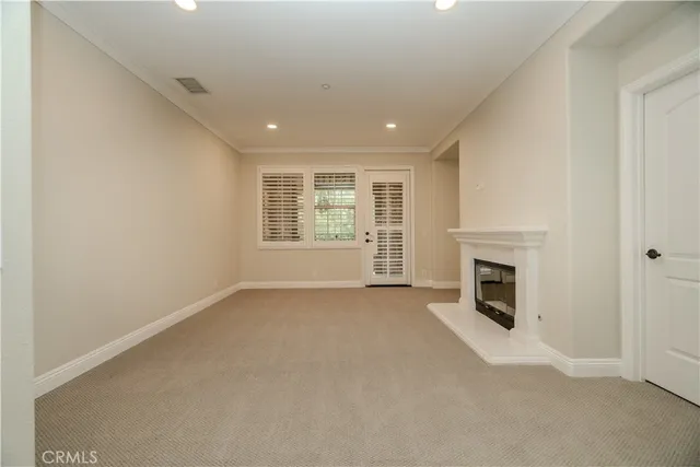 an empty room with windows and fireplace