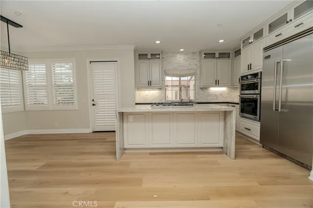 a view of kitchen with granite countertop cabinets and refrigerator