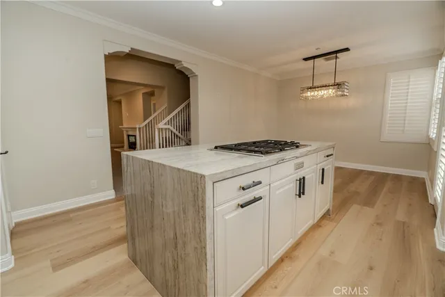 a kitchen with a stove and a wooden floor