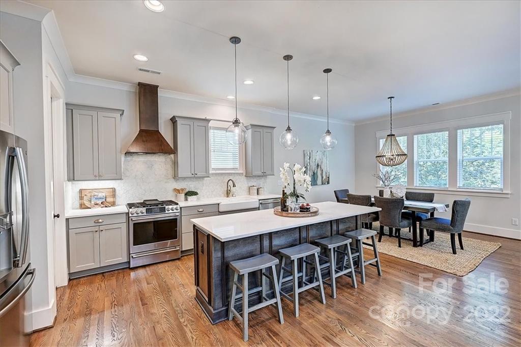 911 Millbrook Road Charlotte, NC 28211 - Photo 13 of 43 a kitchen with stainless steel appliances granite countertop a stove a sink a dining table and chairs with wooden floor