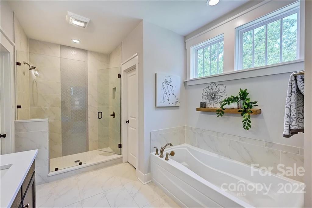 911 Millbrook Road Charlotte, NC 28211 - Photo 31 of 43 a bathroom with a tub shower and window