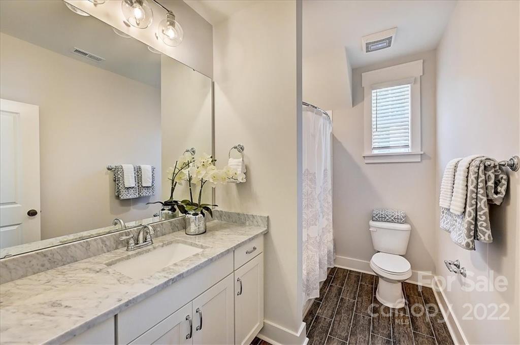 911 Millbrook Road Charlotte, NC 28211 - Photo 35 of 43 a bathroom with a granite countertop sink a toilet and a mirror