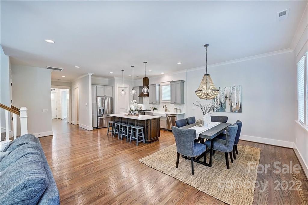 911 Millbrook Road Charlotte, NC 28211 - Photo 9 of 43 a view of a dining room and livingroom with furniture wooden floor a rug and a chandelier