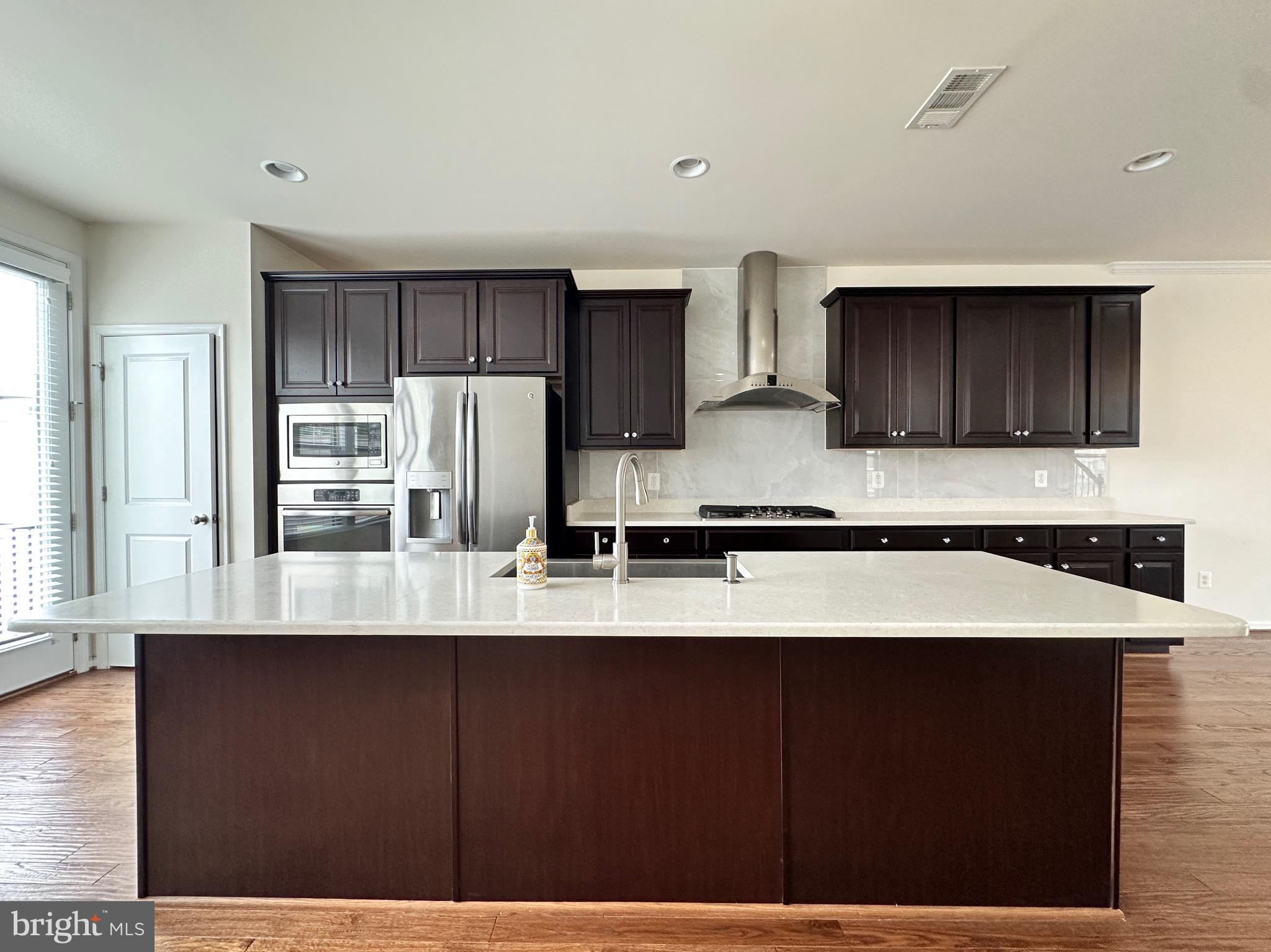 23451 Epperson Square Brambleton, VA 20148 - Photo 17 of 42 a kitchen with refrigerator cabinets and wooden floor