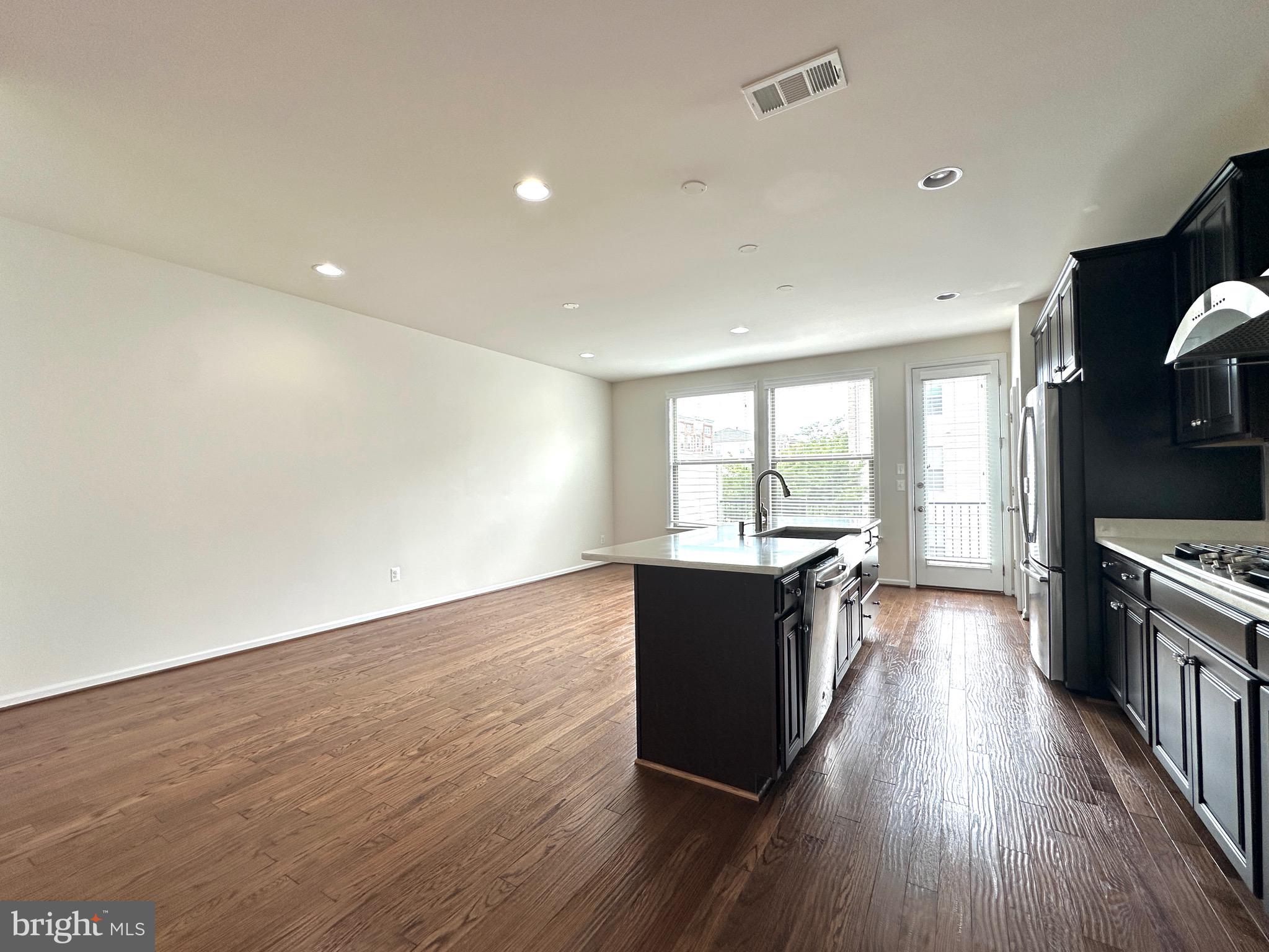 23451 Epperson Square Brambleton, VA 20148 - Photo 19 of 42 a large kitchen with wooden floor and stainless steel appliances